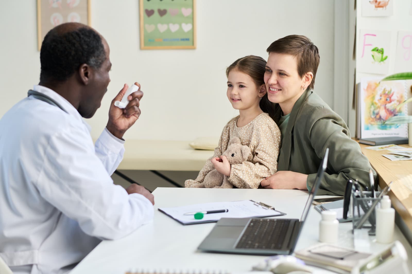 Médica em consulta com mãe e filha no consultório