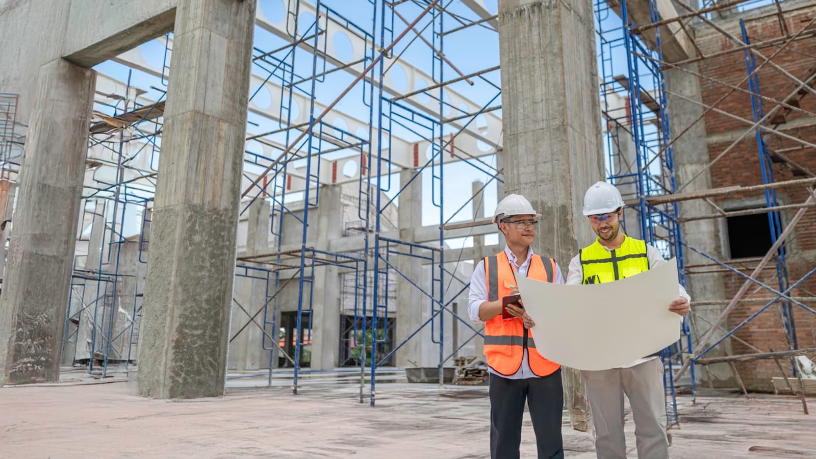 Equipe de engenheiros analisando projeto em obra de construção civil